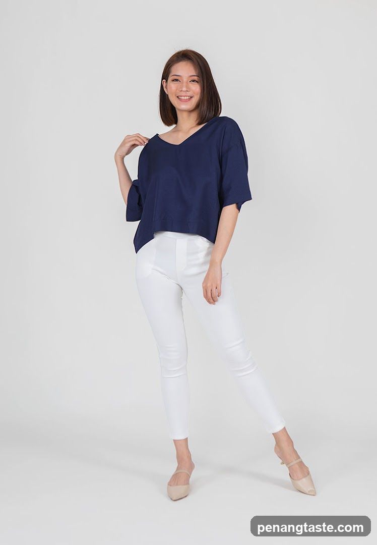 Woman in navy top and white pants