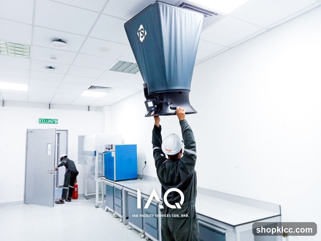 Worker installing industrial equipment in cleanroom facility
