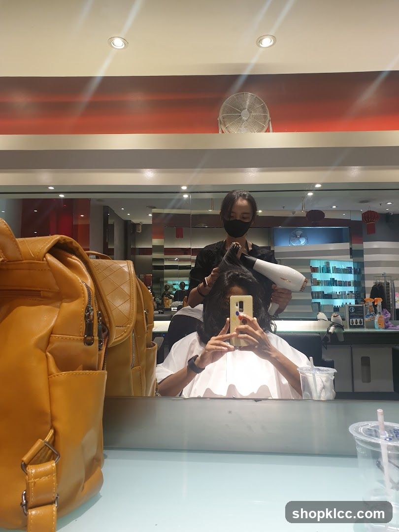 Hairdresser drying client's hair