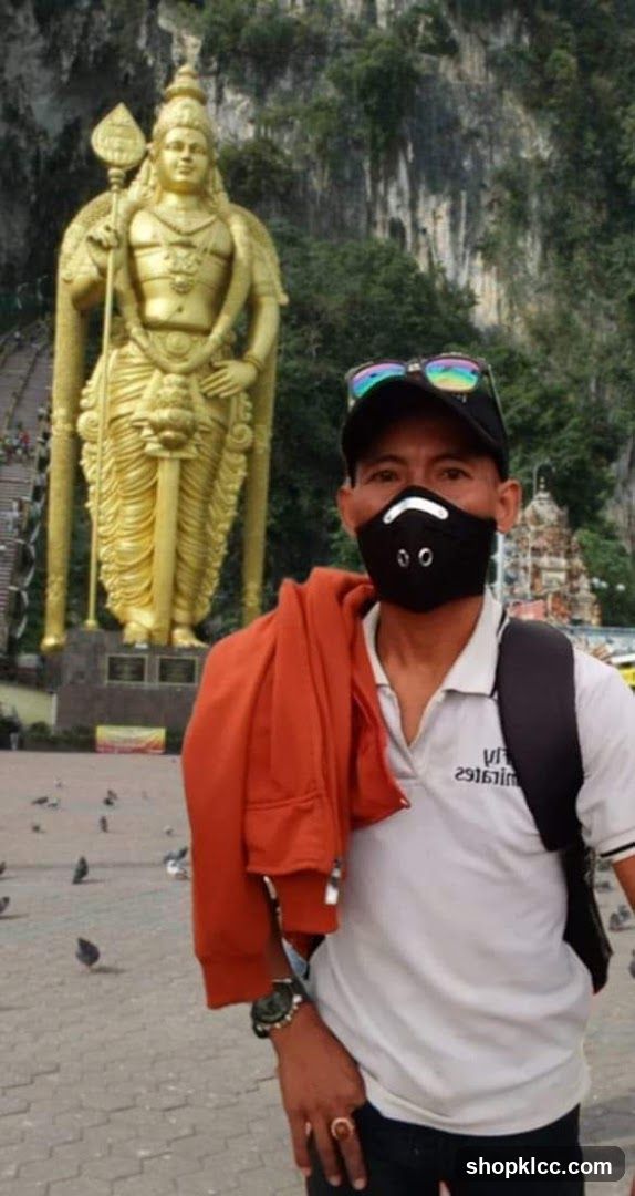 Man Posing in Front of a Large Golden Statue