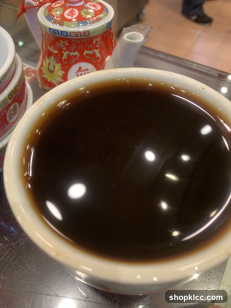 Bowl of Dark Liquid with Decorative Teapot