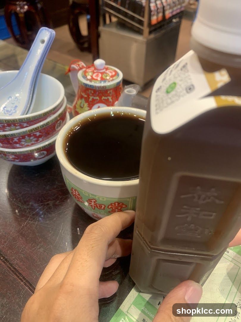 Bowl of dark liquid with condiment bottle