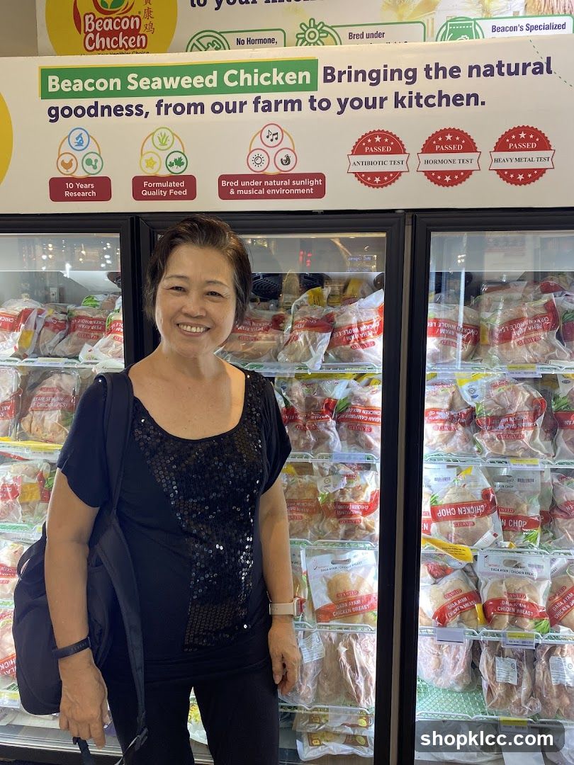 Woman in front of refrigerated display of chicken products