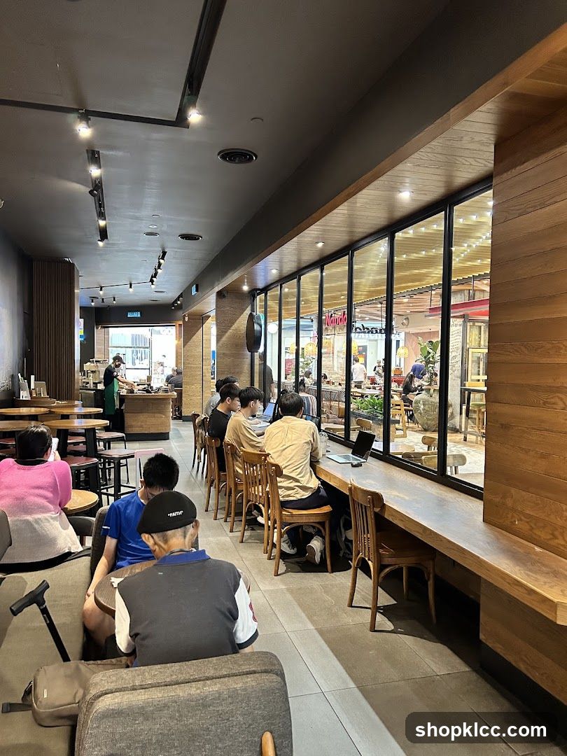 Interior of a modern café with customers seated at tables and along the window