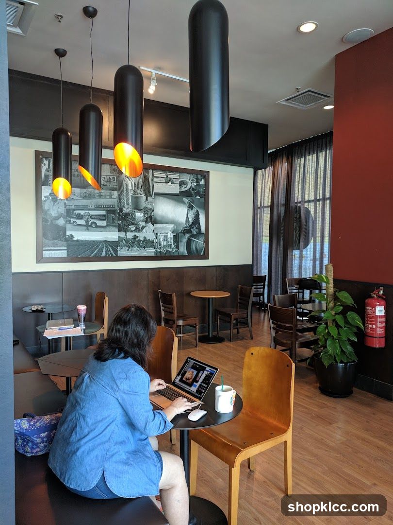 Interior of a coffee shop with customer working on laptop