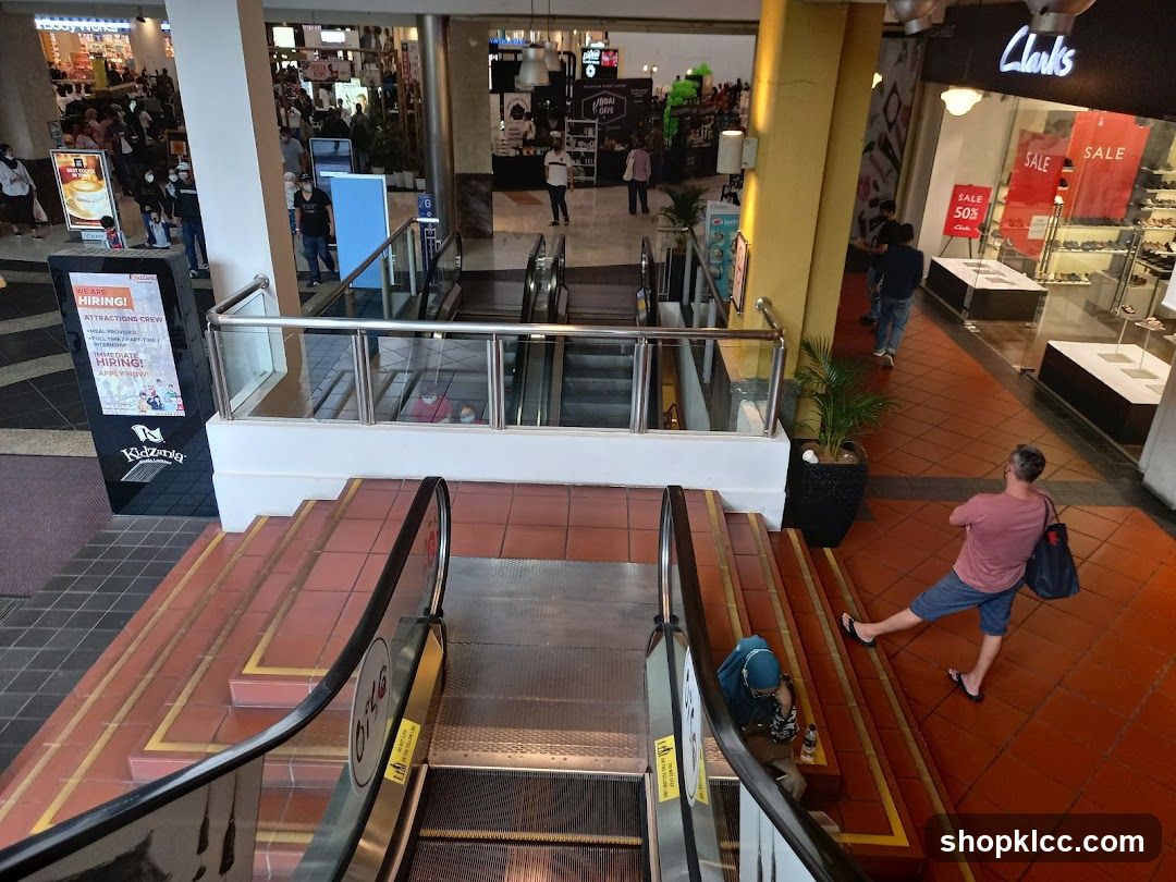 Shopping Mall Interior with Escalators and Storefronts