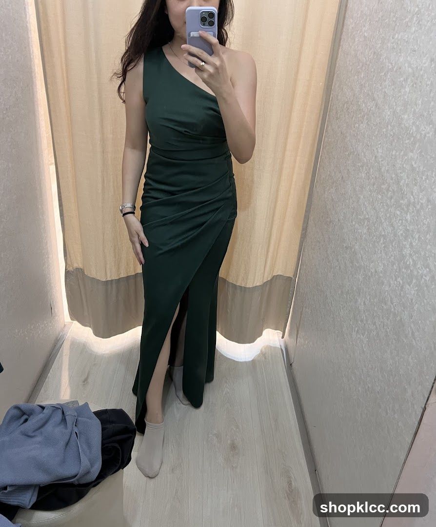 Woman in a dark green one-shoulder dress