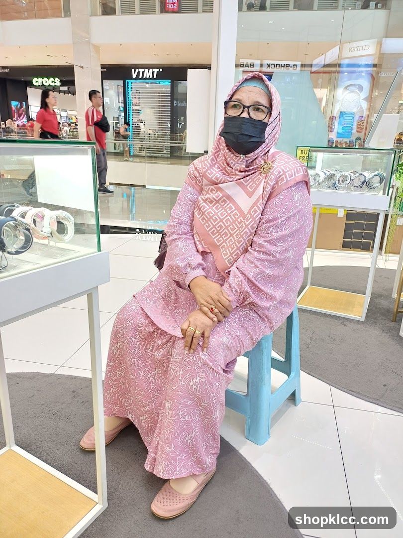 Woman in pink hijab sitting in mall jewelry store