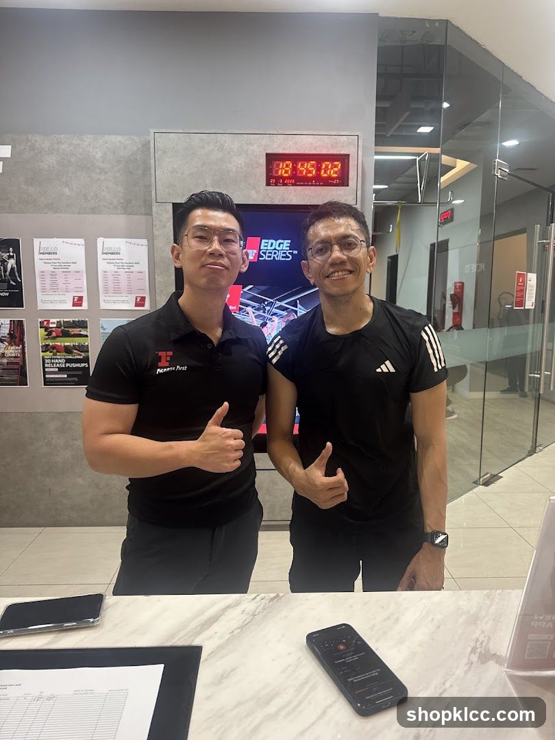 Two men giving thumbs up in a gym