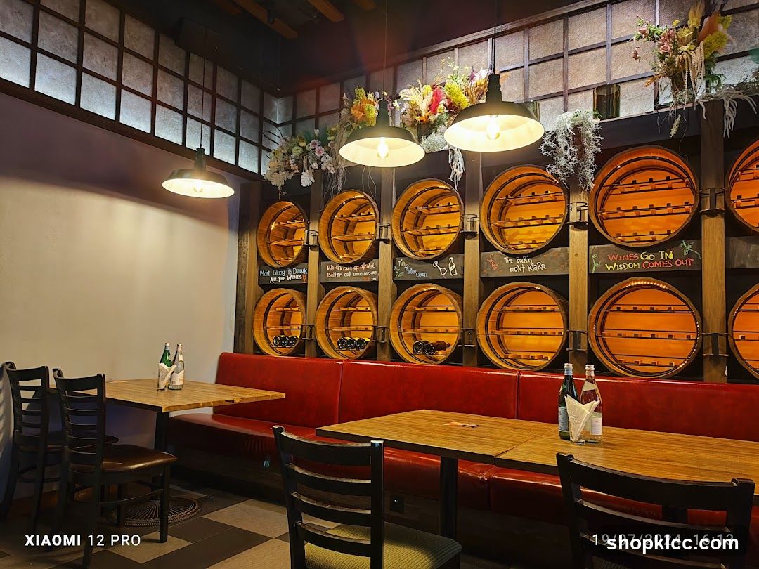 Interior of a cozy restaurant with wooden barrels and red booth seating