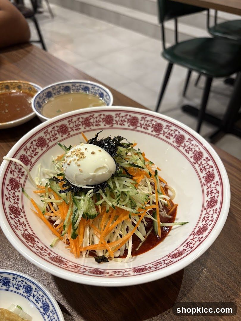 Bowl of Korean-style cold noodle salad with egg and vegetables