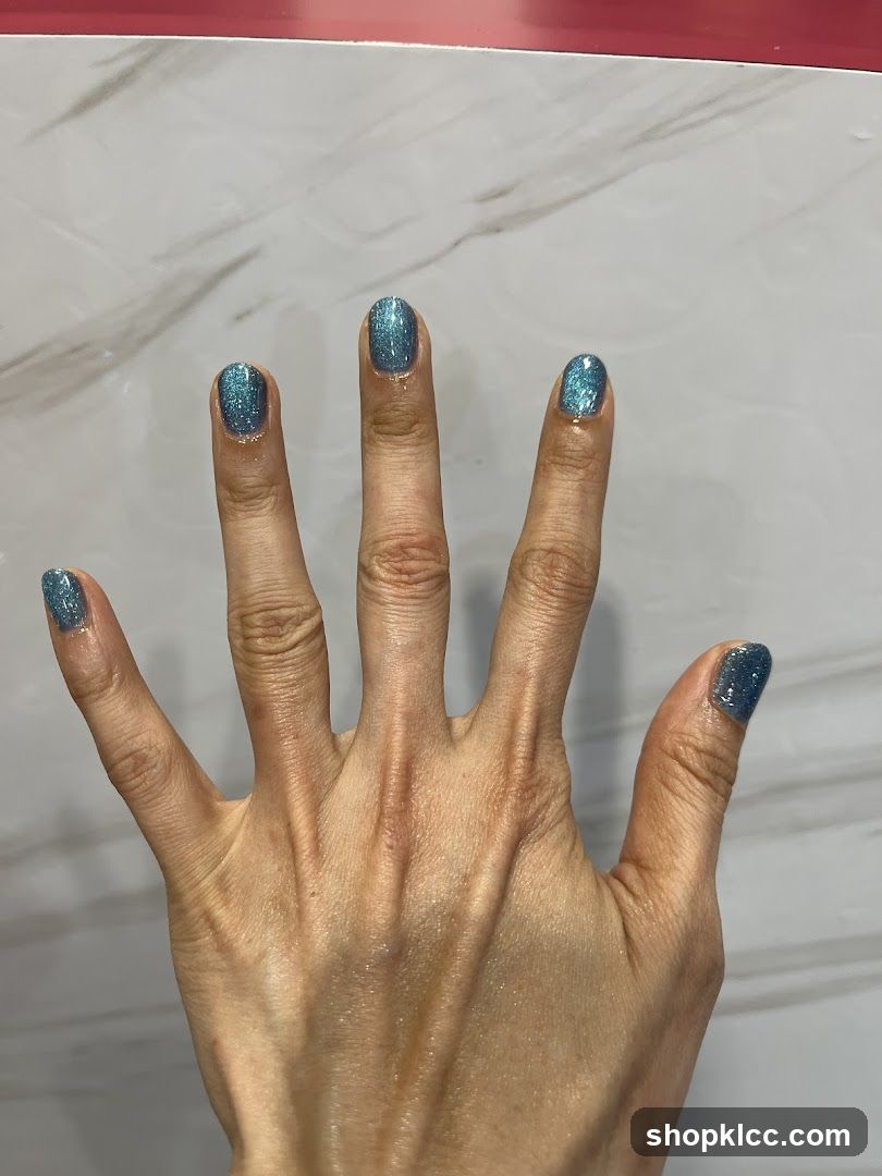 Hand with Blue Glitter Nail Polish