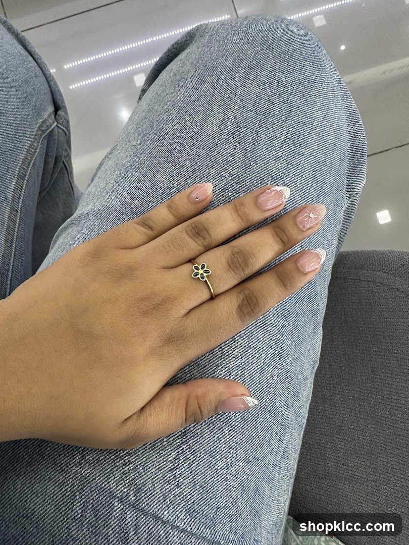 Woman's hand with flower ring and French manicure