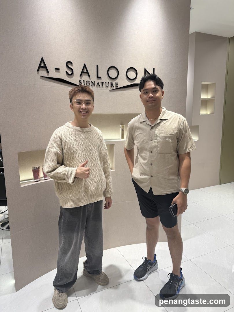 Two men in front of a salon sign