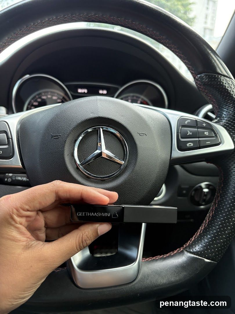 Hand holding a lipstick case in a car