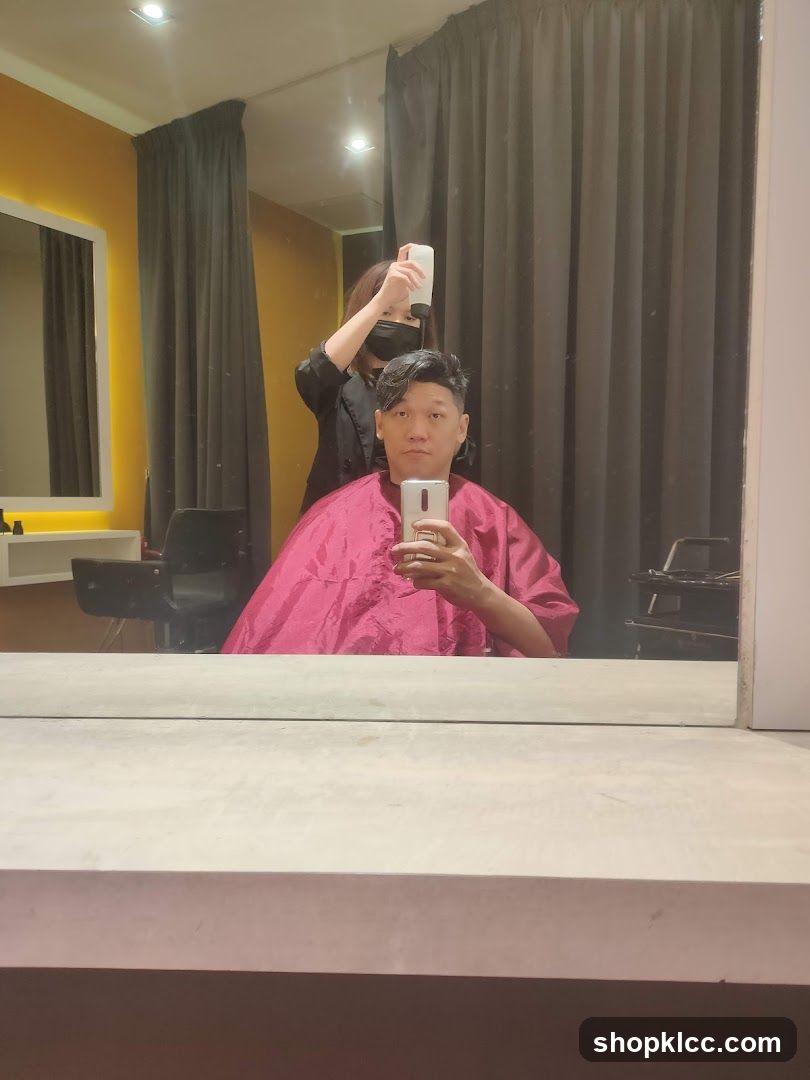 Hairdresser spraying client's hair