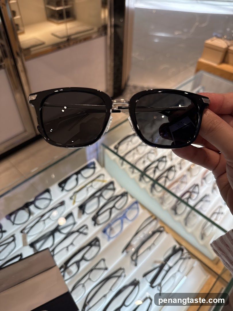 Hand holding sunglasses in an optical shop