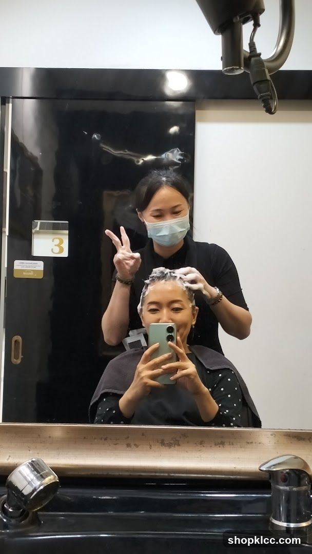 Hairdresser washing client's hair