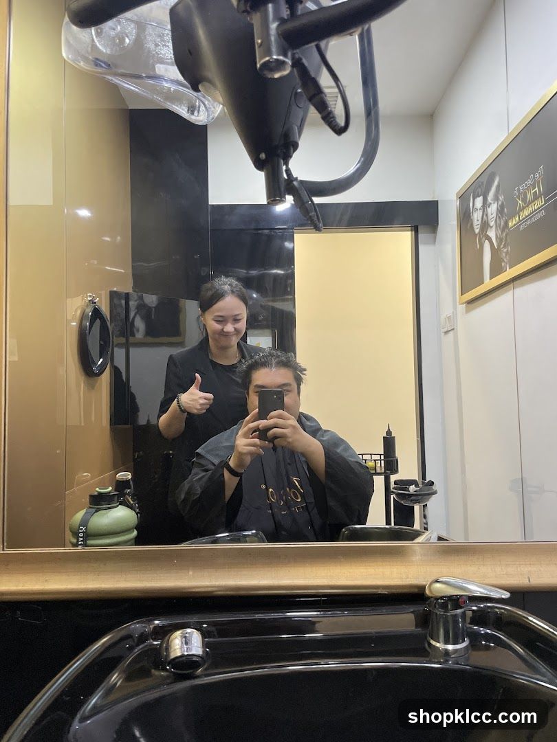 Hairdresser giving a thumbs up to a client