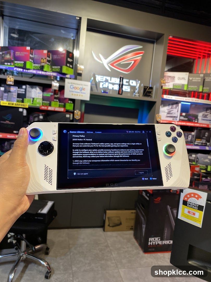 Hand holding a white gaming handheld device with a privacy policy on screen