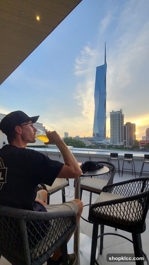 Man drinking beer on a rooftop with city view