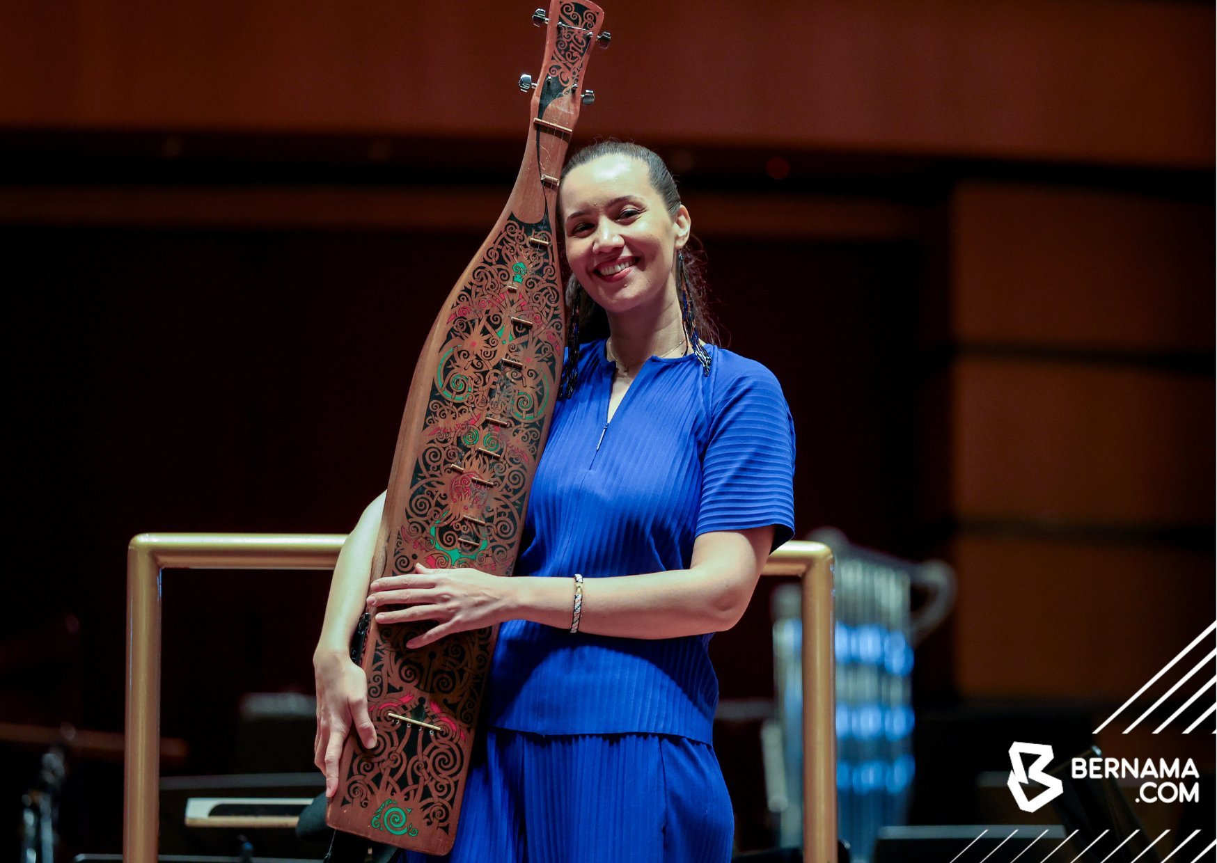 Alena Murang holding a carved sape' on the Dewan Filharmonik PETRONAS stage, Bernama photo